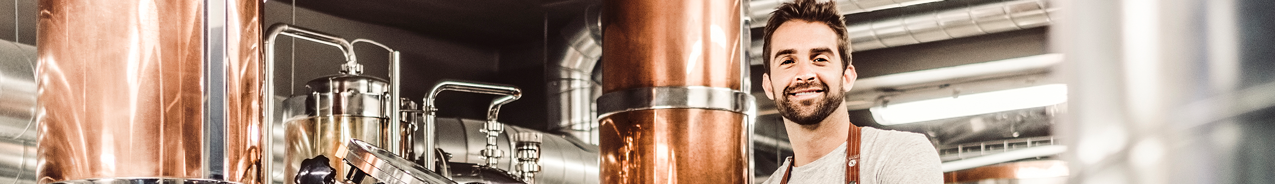 man wearing industrial apron in front of complex machinery